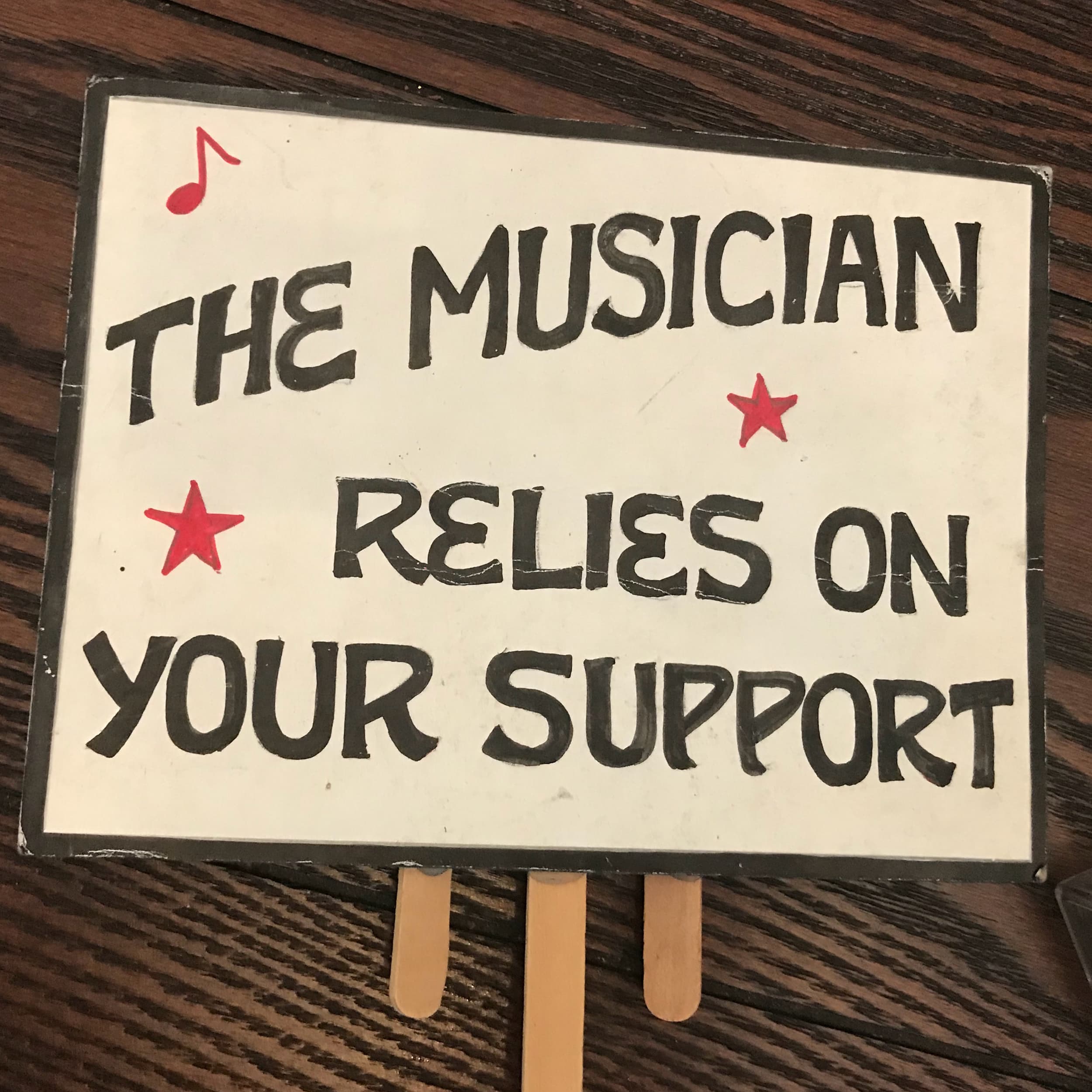 Handmade sign reading the musician relies on your support